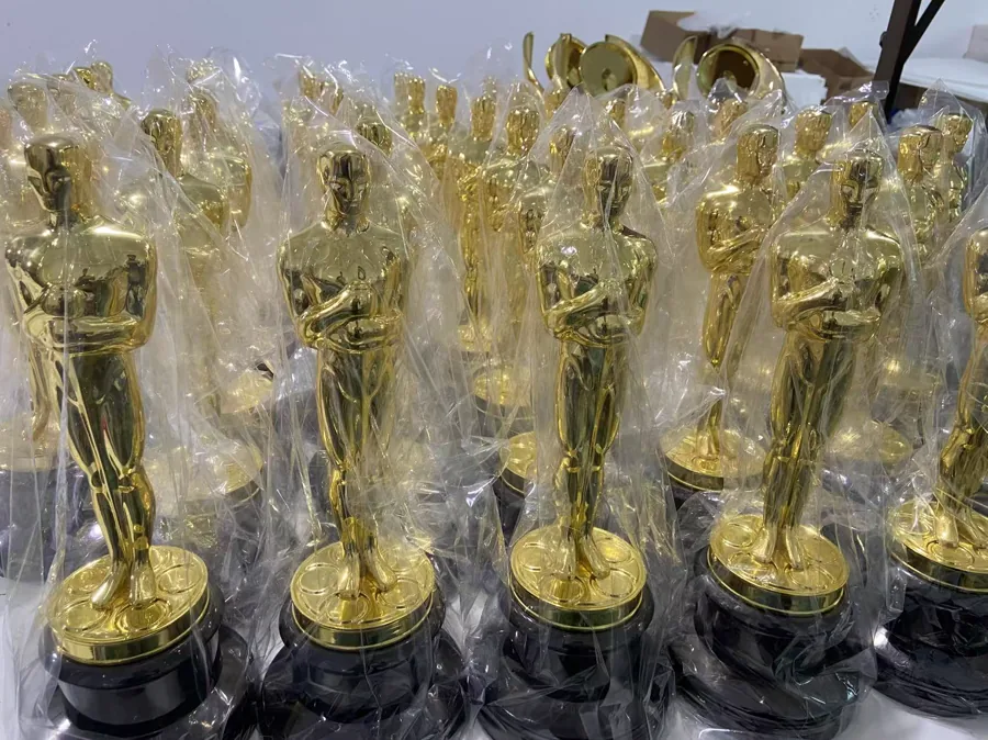 A production batch of gold-colored award statuettes individually protected for packing